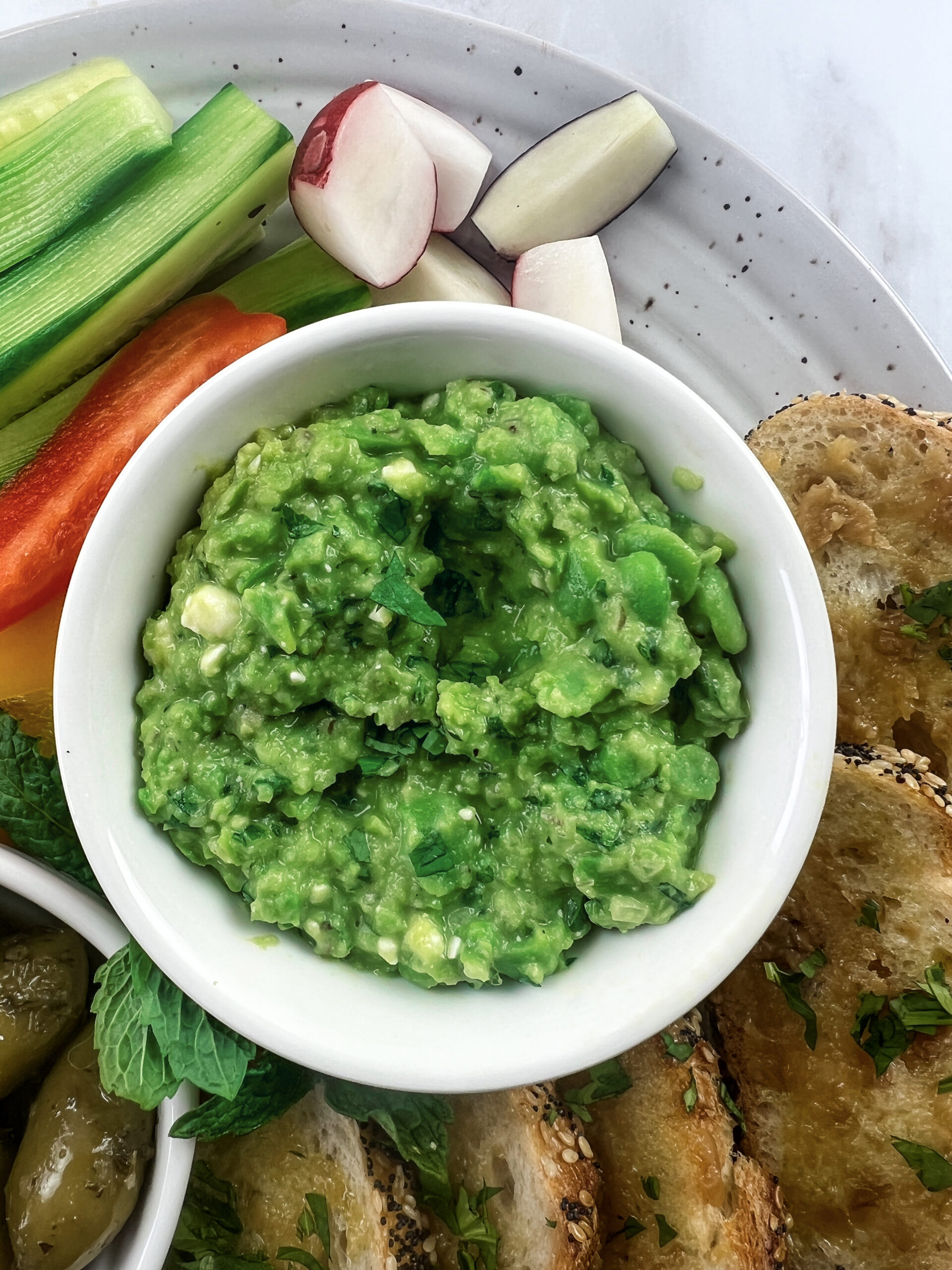 Fresh fava bean dip with pita chips and vegetables.