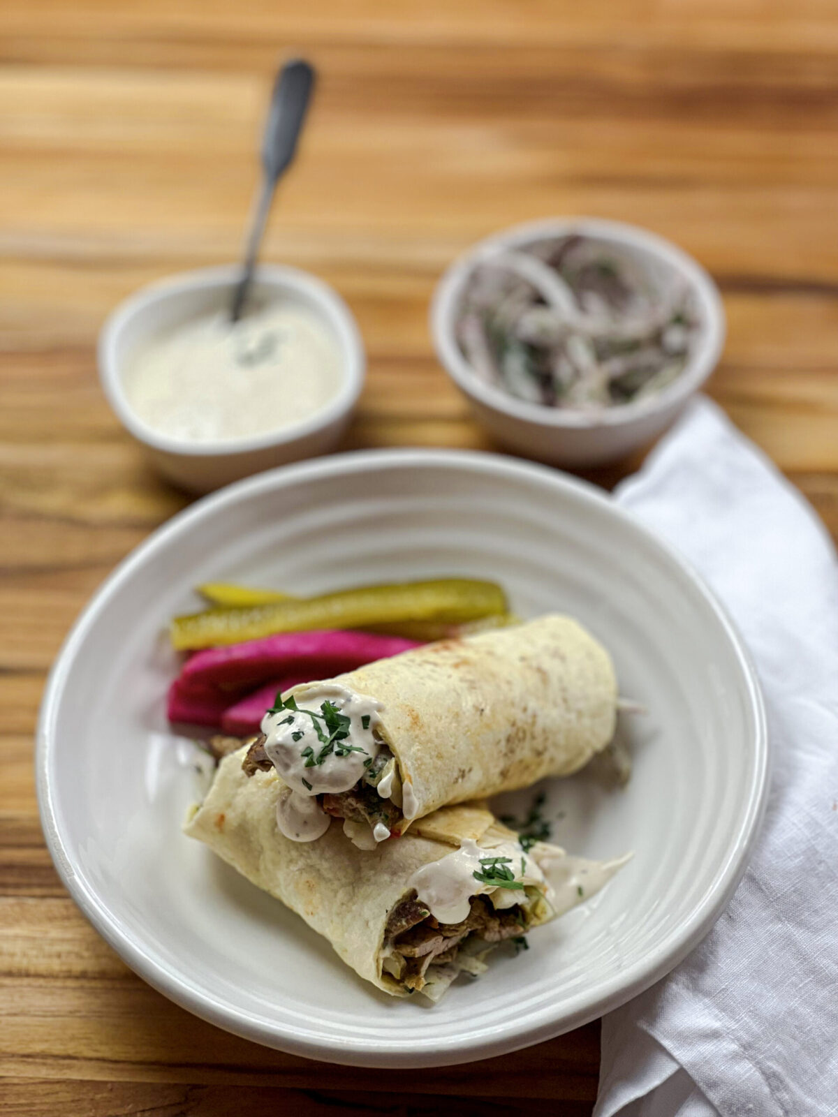 A delicious homemade shawarma wrap with sliced chicken, vegetables, and tzatziki sauce wrapped in a warm pita bread