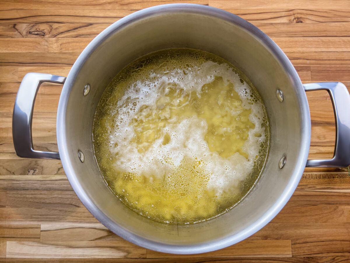 Elbow macaroni boiling in a large pot of salted water.