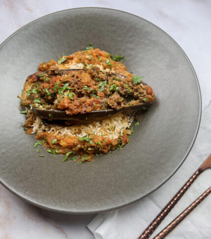 A mouthwatering final presentation of Stuffed Eggplant Karniyarik garnished with fresh herbs.