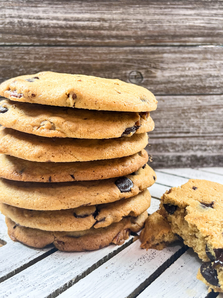 A stack of freshly baked Tahini Pecan Chocolate Chip Cookies on a plate.