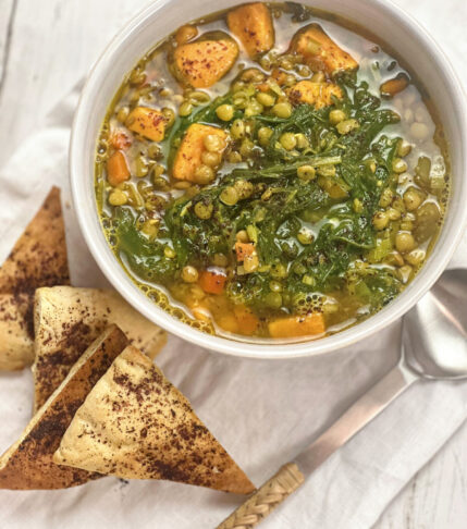 Bowl of Lentil Soup with Kale and Sweet Potatoes, accompanied by sliced pita bread.