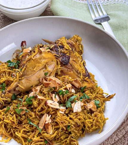 A plate of golden vermicelli noodles topped with seasoned chicken pieces, reflecting traditional Middle Eastern flavors.