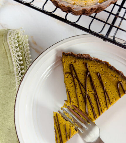 A slice of pumpkin chocolate tart on a white plate.