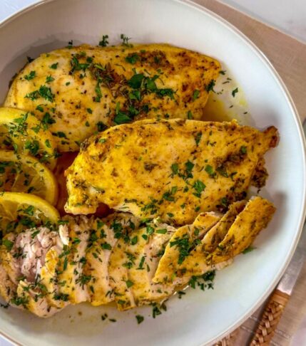 A platter of succulent Middle Eastern-inspired baked chicken breasts garnished with fresh herbs and lemon slices