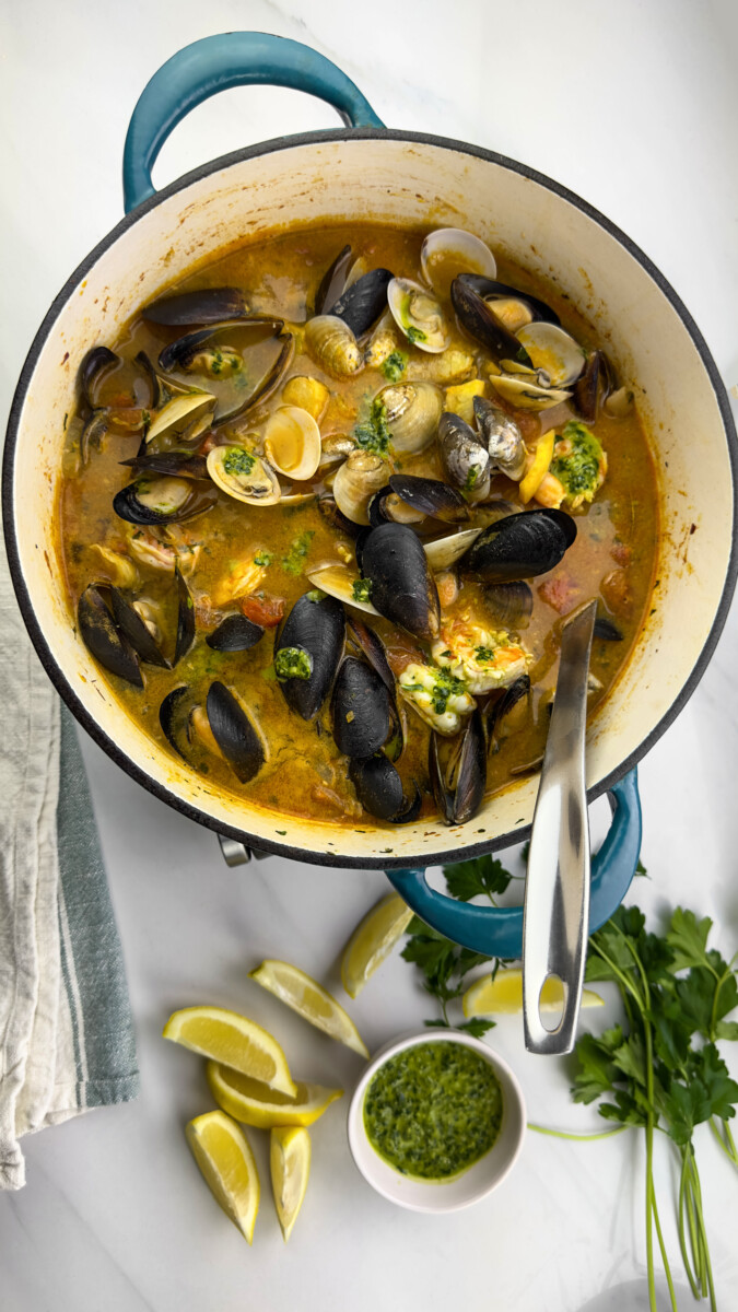 Adding mussels and clams to the stew, waiting for them to open.