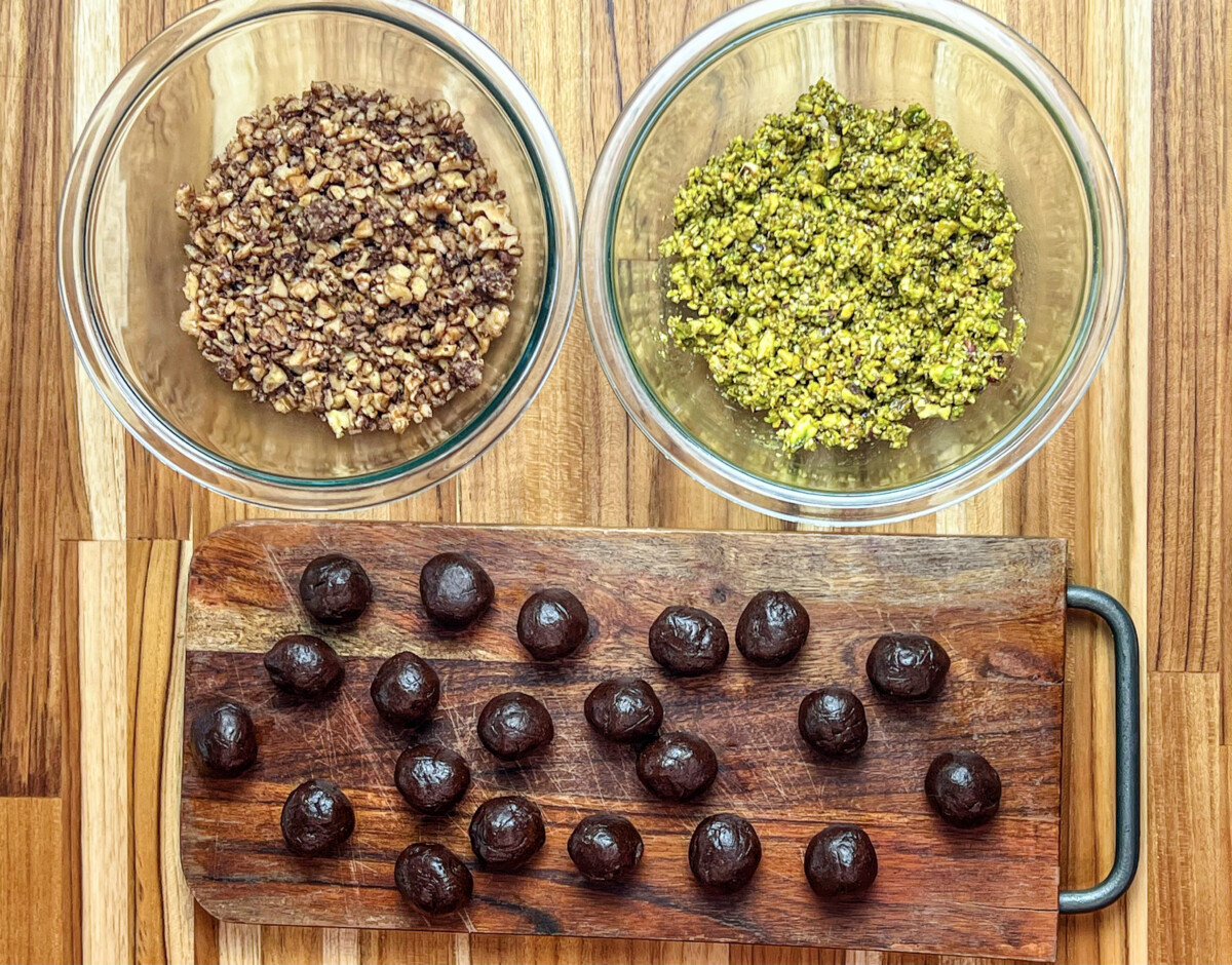 A photo showing three separate bowls filled with walnut, date, and pistachio fillings for Mammoul cookies. The walnuts are finely chopped, the dates are mashed into a paste, and the pistachios are ground to create a fine texture. The fillings are an essential part of the cookie-making process and provide a delicious balance of sweet and nutty flavors