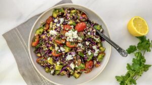 A delicious bowl of Mediterranean-style black bean salad topped with feta and sprinkles of sumac.