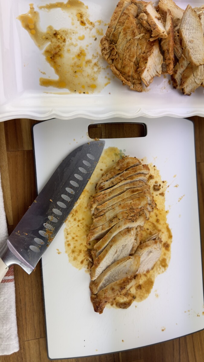 Close up of a knife slicing through cooked chicken breast
