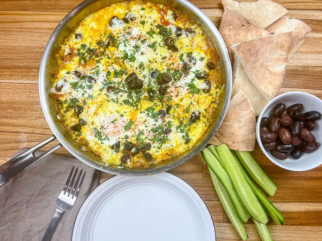 Close-up of a traditional Shakshuka dish, a staple in Mediterranean cuisine, featuring poached eggs nestled in a rich tomato and bell pepper sauce.