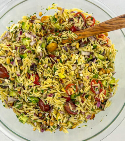 Bowl filled with colorful Greek Orzo Salad, showcasing the blend of orzo pasta, fresh vegetables, feta cheese, and tangy dressing.