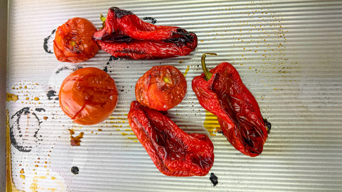 Vegetables roasting in the oven, their skins charred and blistered.