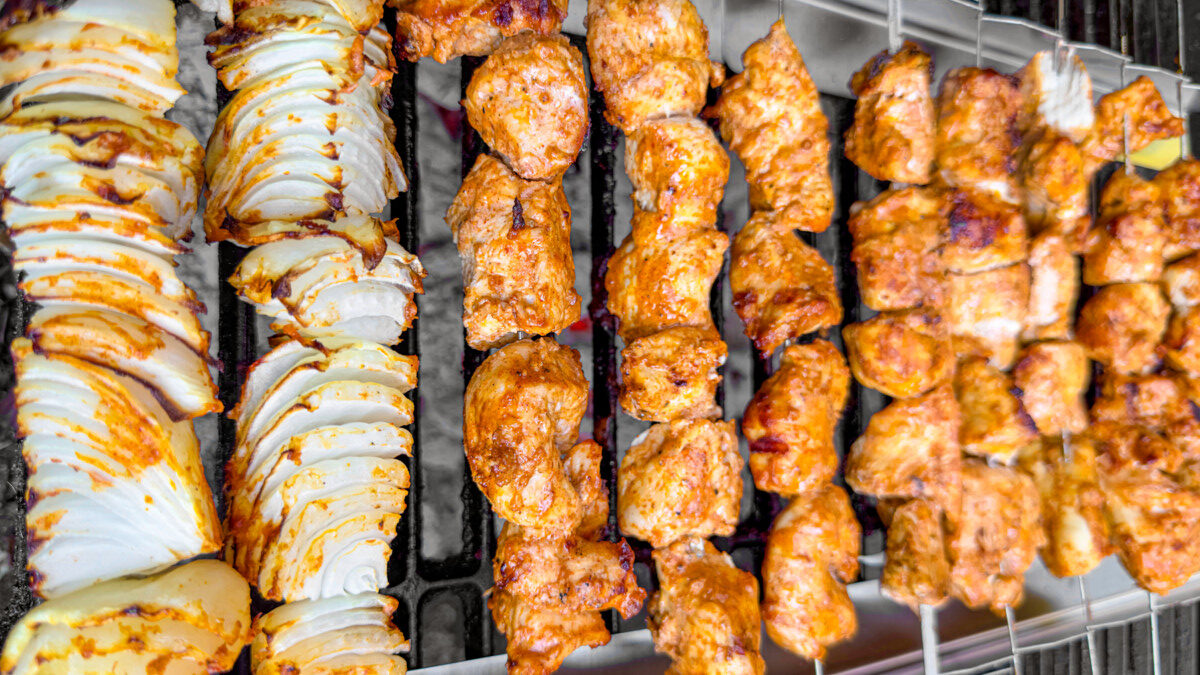 Chicken kebabs grilling with prominent grill marks.