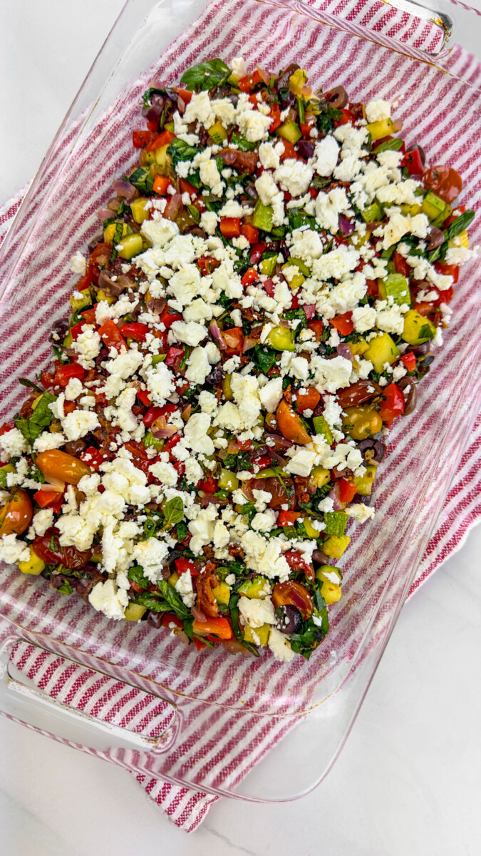 Vegetable casserole base sprinkled with crumbled feta cheese