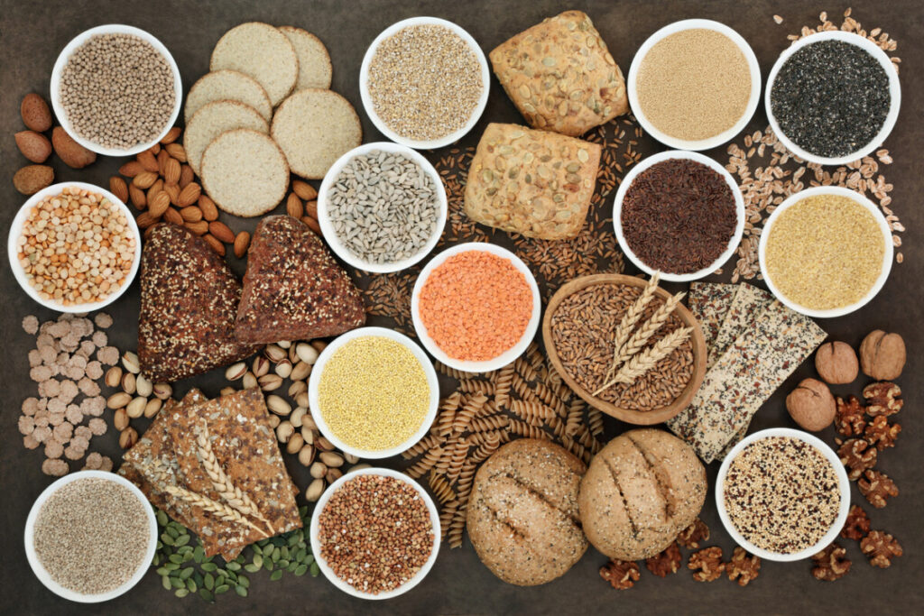 Assorted whole grains and legume seeds displayed in small bowls.