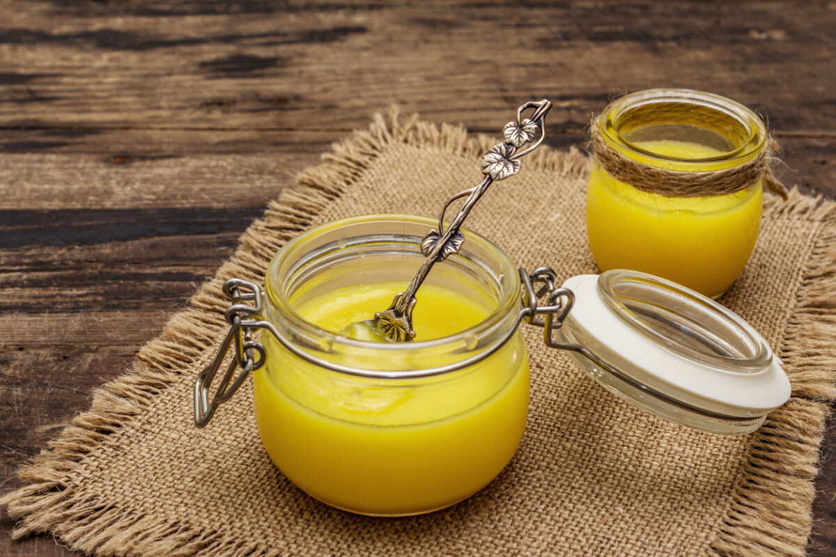 Ghee in glass jars with a silver spoon