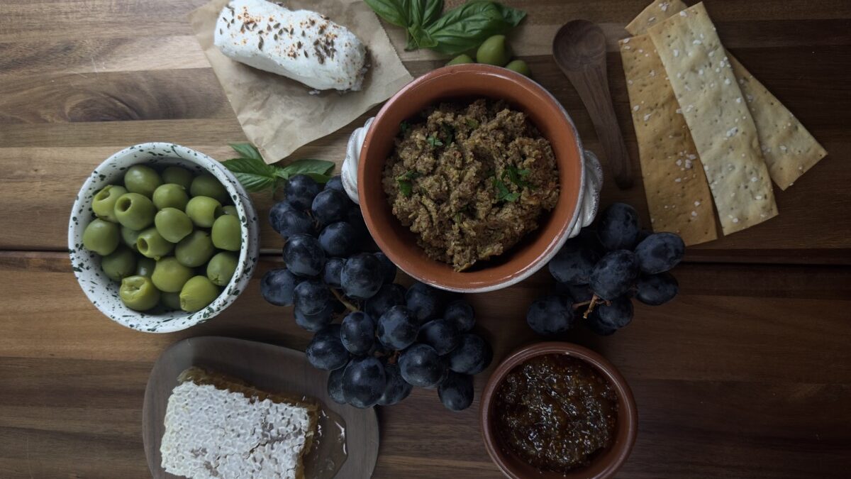 Finished Olive Tapenade Displayed with Jam, Grapes, and Fresh Bread
