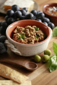Finished Olive Tapenade Displayed with Jam, Grapes, and Fresh Bread