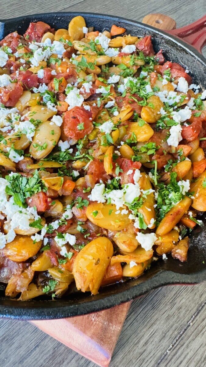 Culinary masterpiece in a cast iron – Baked Greek Beans adorned with feta and fresh Italian parsley.