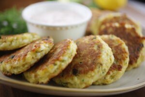 Plating crispy halloumi fritters with fresh herbs and a zesty yogurt dip