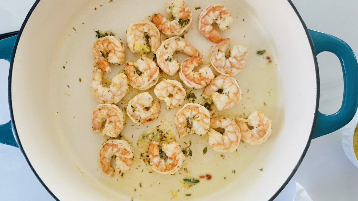 Cooking marinated shrimp in a skillet, two minutes per side.