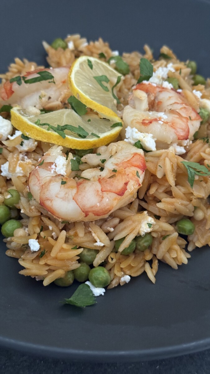 Close-up of the final shrimp orzo dish garnished with thin lemon slices