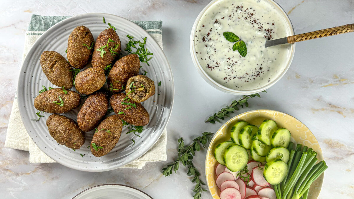 Lebanese kibbeh with a bowl of yogurt and mix veggies 