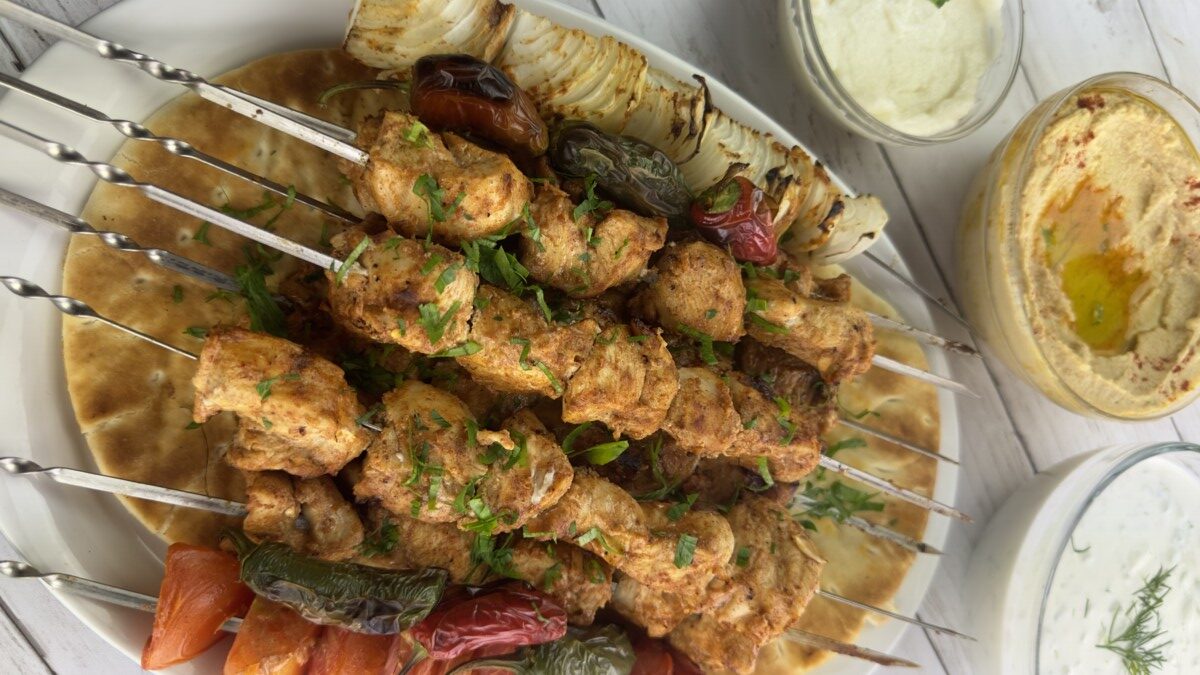 chicken kabab skewers with some dips dishes