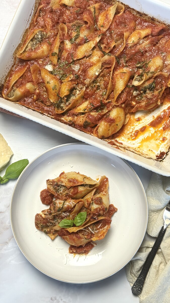 Golden-baked stuffed pasta shells topped with tomato sauce, melted parmesan cheese, and garnished with fresh parsley."