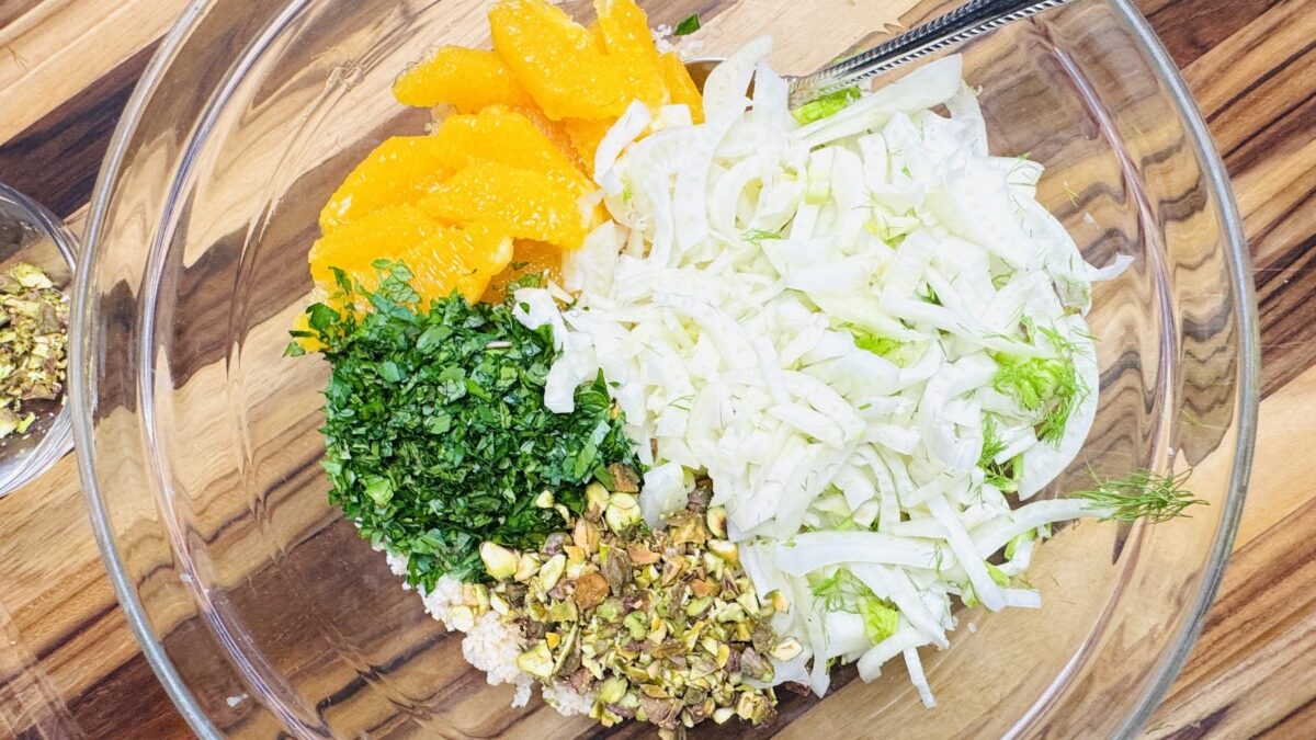 Mediterranean Bulgur Salad with fennel, oranges, and pistachios, tossed in a creamy yogurt dressing, served in a bowl.