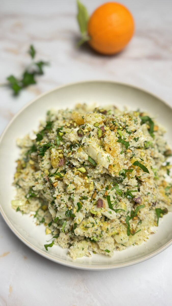 Mediterranean Bulgur Salad with fennel, oranges, and pistachios, tossed in a creamy yogurt dressing, served in a bowl.