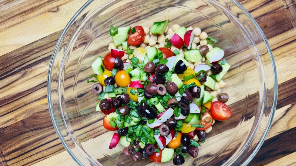 Measured ingredients for Mediterranean Garbanzo Bean Salad, including chickpeas, fresh veggies, herbs, and pomegranate molasses dressing."