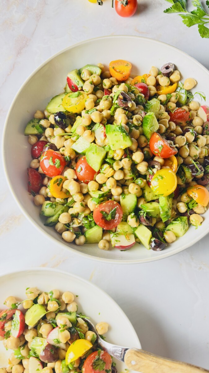 Mediterranean Garbanzo Bean Salad tossed with pomegranate molasses dressing in a large bowl."