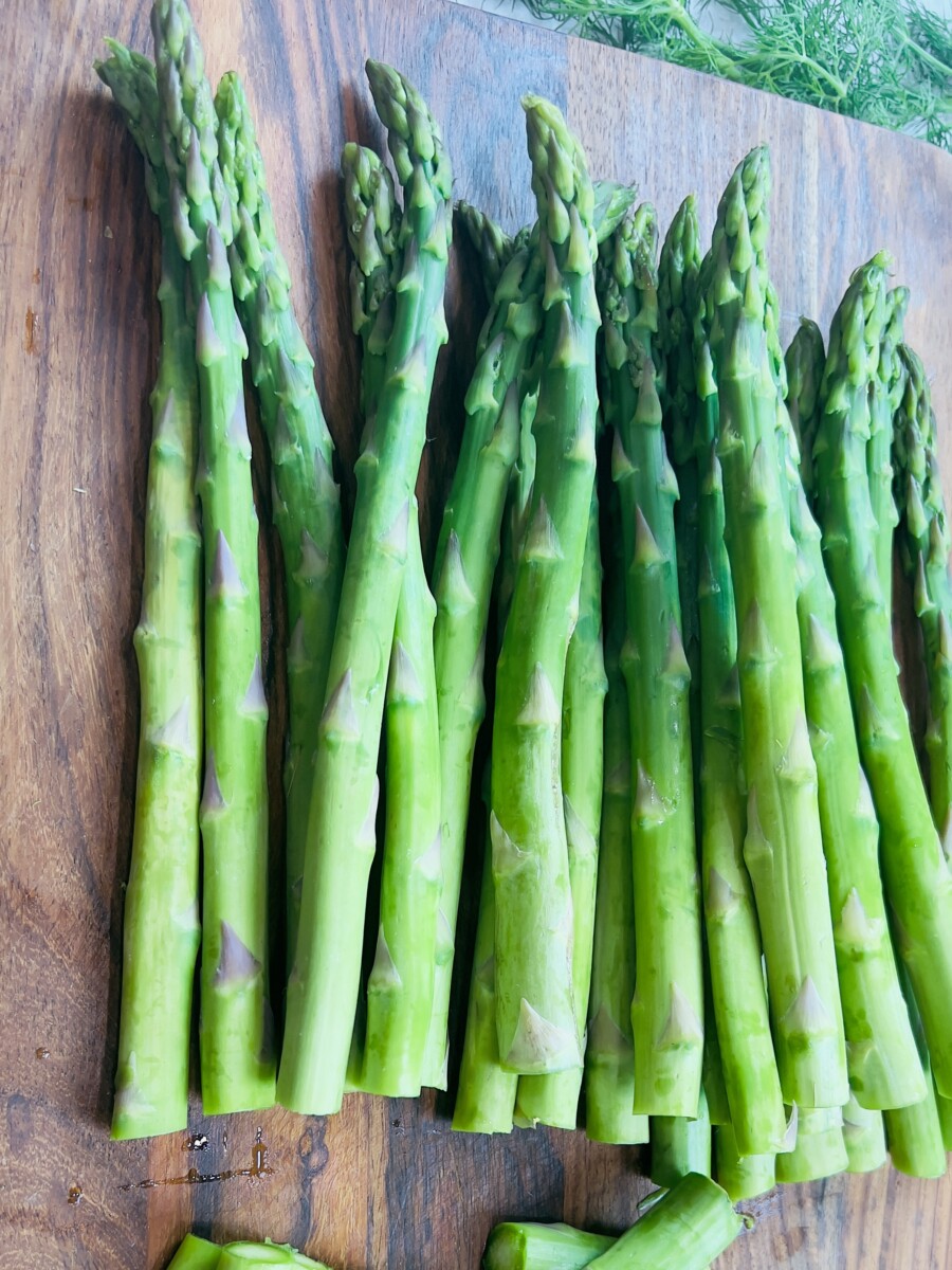 Blanched asparagus on a cutting board, ready to be chopped into smaller pieces for a fresh and vibrant dish.