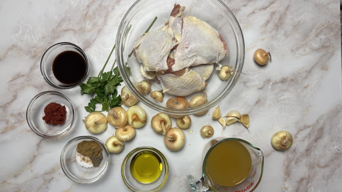 All ingredients for Pomegranate Roasted Chicken measured and ready to use, including chicken, pomegranate molasses, cipollini onions, olive oil, garlic, and fresh herbs.