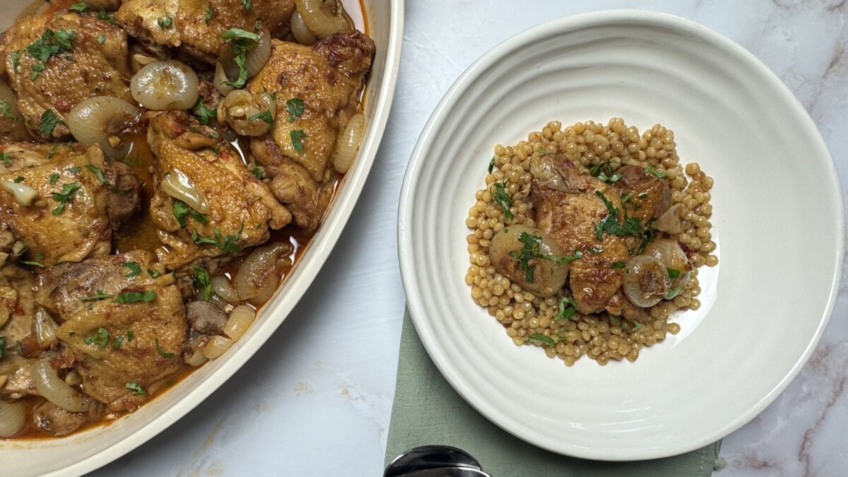 Pomegranate Roasted Chicken served over fluffy couscous, garnished with fresh parsley for a vibrant Mediterranean meal.