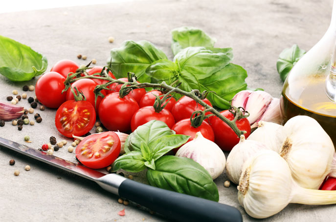 A platter of fresh ingredients, tomatoes, garlic basil, 