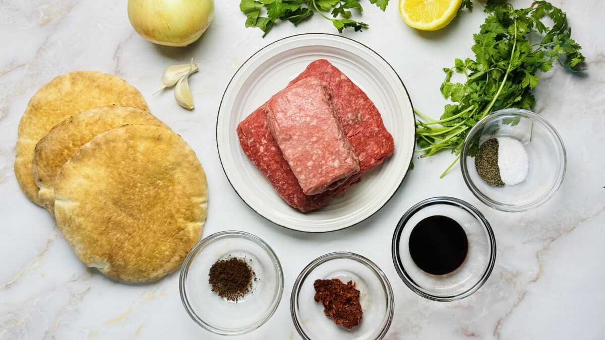 All ingredients measured and prepped for making Middle Eastern Arayes, including ground meat, fresh herbs, spices, and pita bread.
