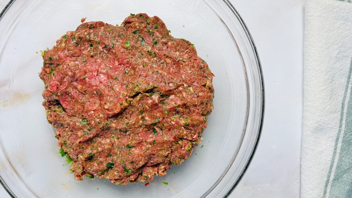 Well-mixed spiced meat filling in a bowl, ready to be chilled before stuffing into pita for Arayes.