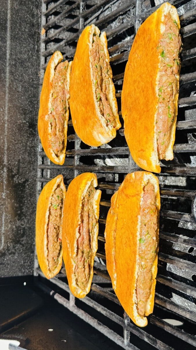 Stuffed pita Arayes on the grill, toasted with golden-brown edges and nearly ready to be served.