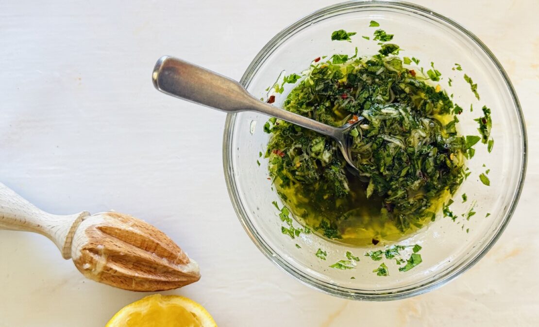 Lemon herb marinade in a small bowl with olive oil, garlic, herbs, and lemon zest