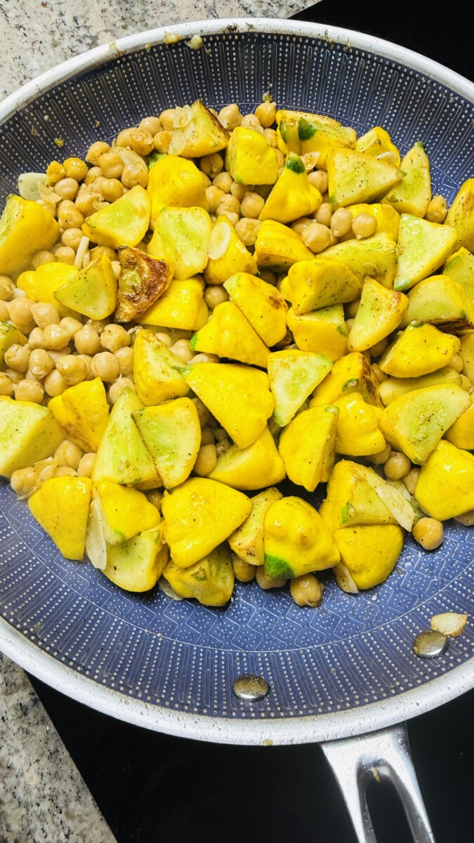 Chickpeas added to the sautéed summer squash and stirred together in the skillet.