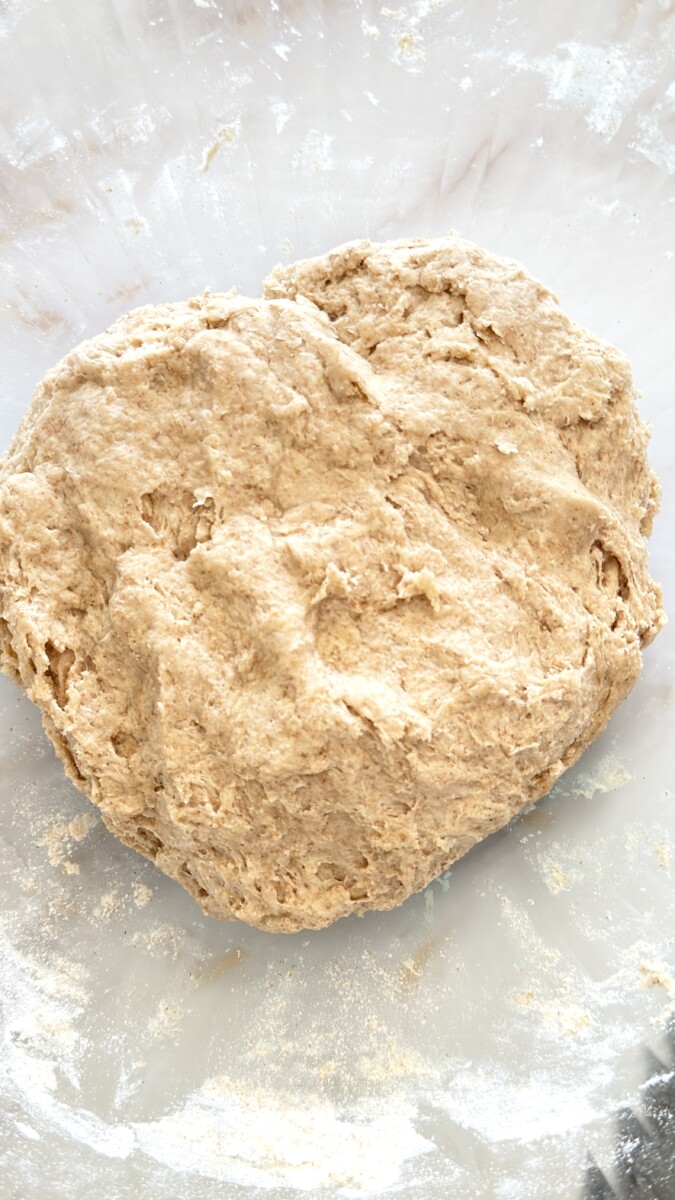 Mixing wet and dry ingredients into a rough shaggy dough for homemade pita bread.