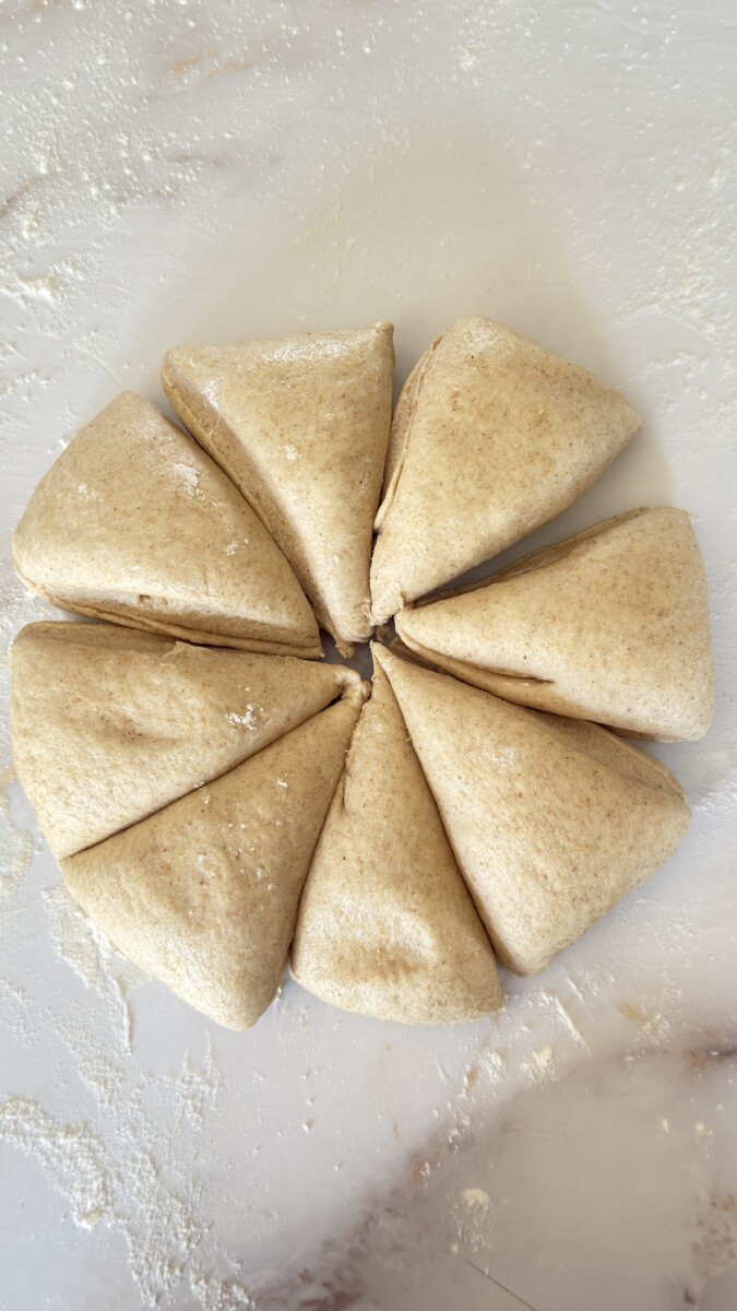 Pita bread dough cut into 8 almost equal triangle-shaped portions.