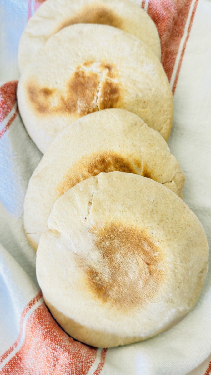 Freshly baked pita bread wrapped in a towel to keep warm.