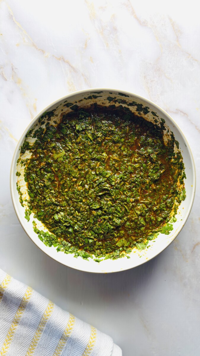 Vibrant Moroccan chermoula marinade after mixing — a thick, aromatic blend of herbs, spices, and saffron water ready to coat the fish for tagine.