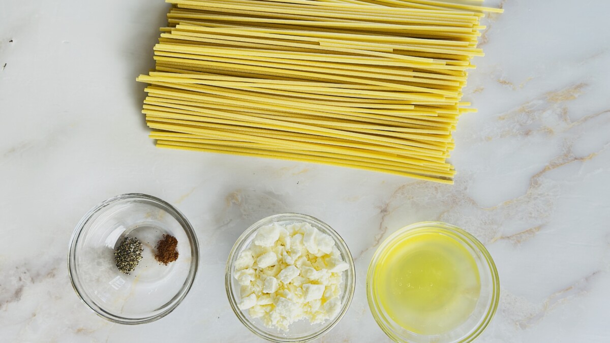Ingredients for Greek Pastitsio pasta layer — bucatini pasta, feta cheese, egg whites, nutmeg, and black pepper.