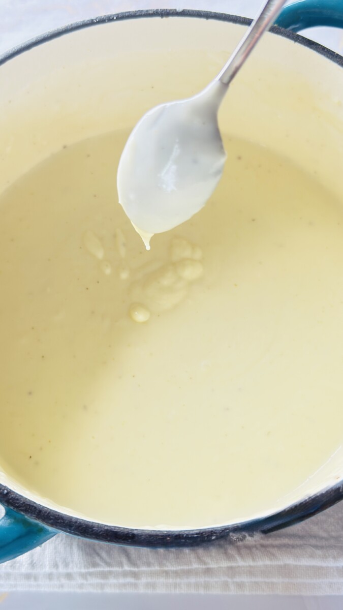 Finished béchamel sauce for Greek Pastitsio, smooth and creamy after adding cheese, nutmeg, and egg yolks.