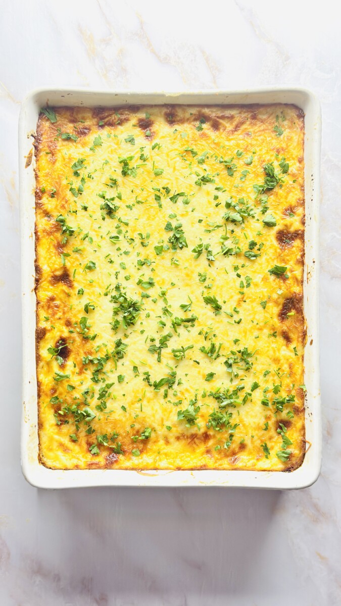 Greek Pastitsio fresh out of the oven, golden and bubbly, resting before slicing to let the layers set.