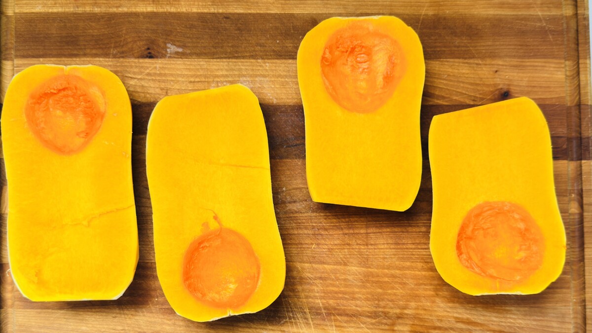 Peeled butternut squash halves with seeds removed on cutting board